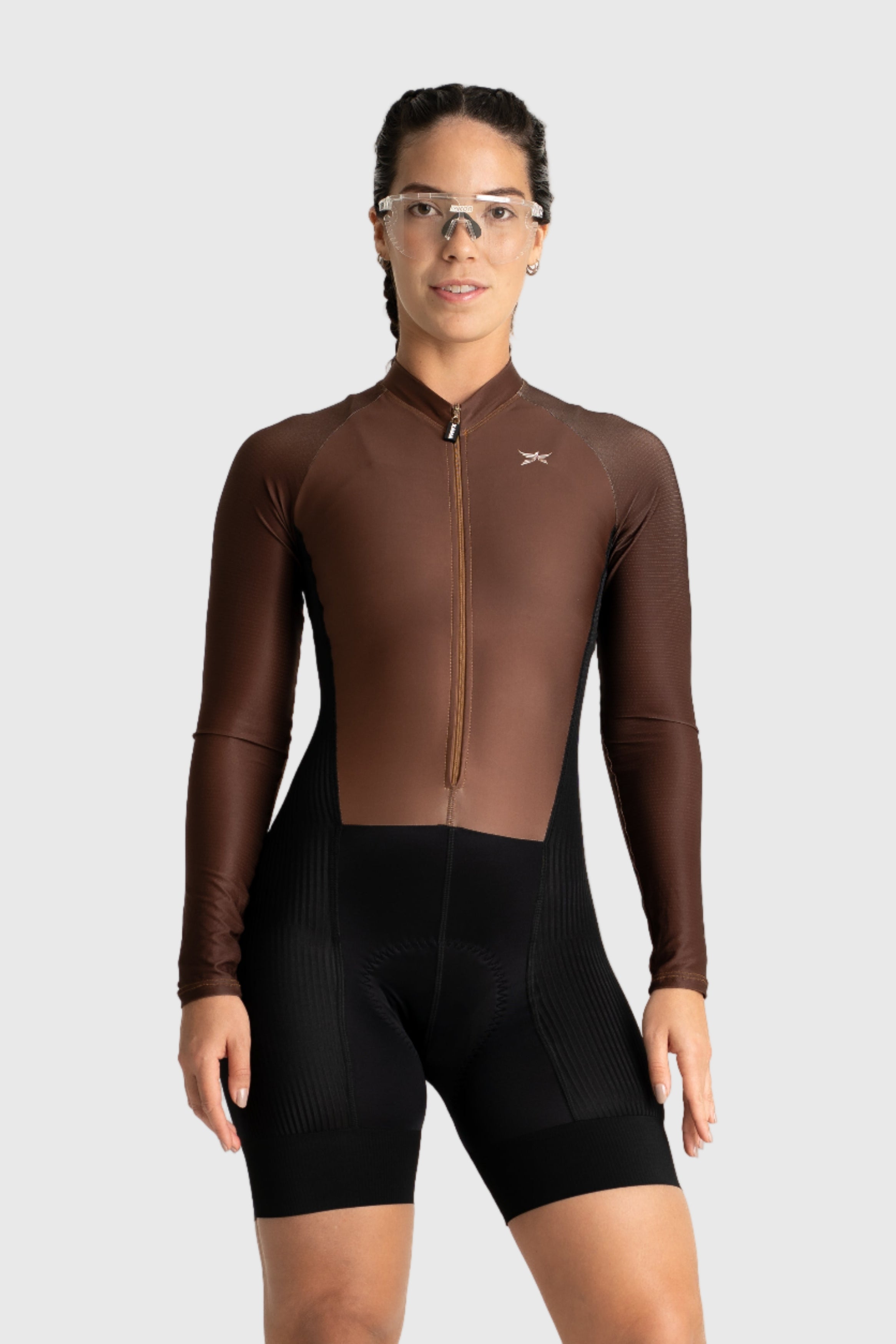 Person wearing a brown cycling suit and black shorts on a white background