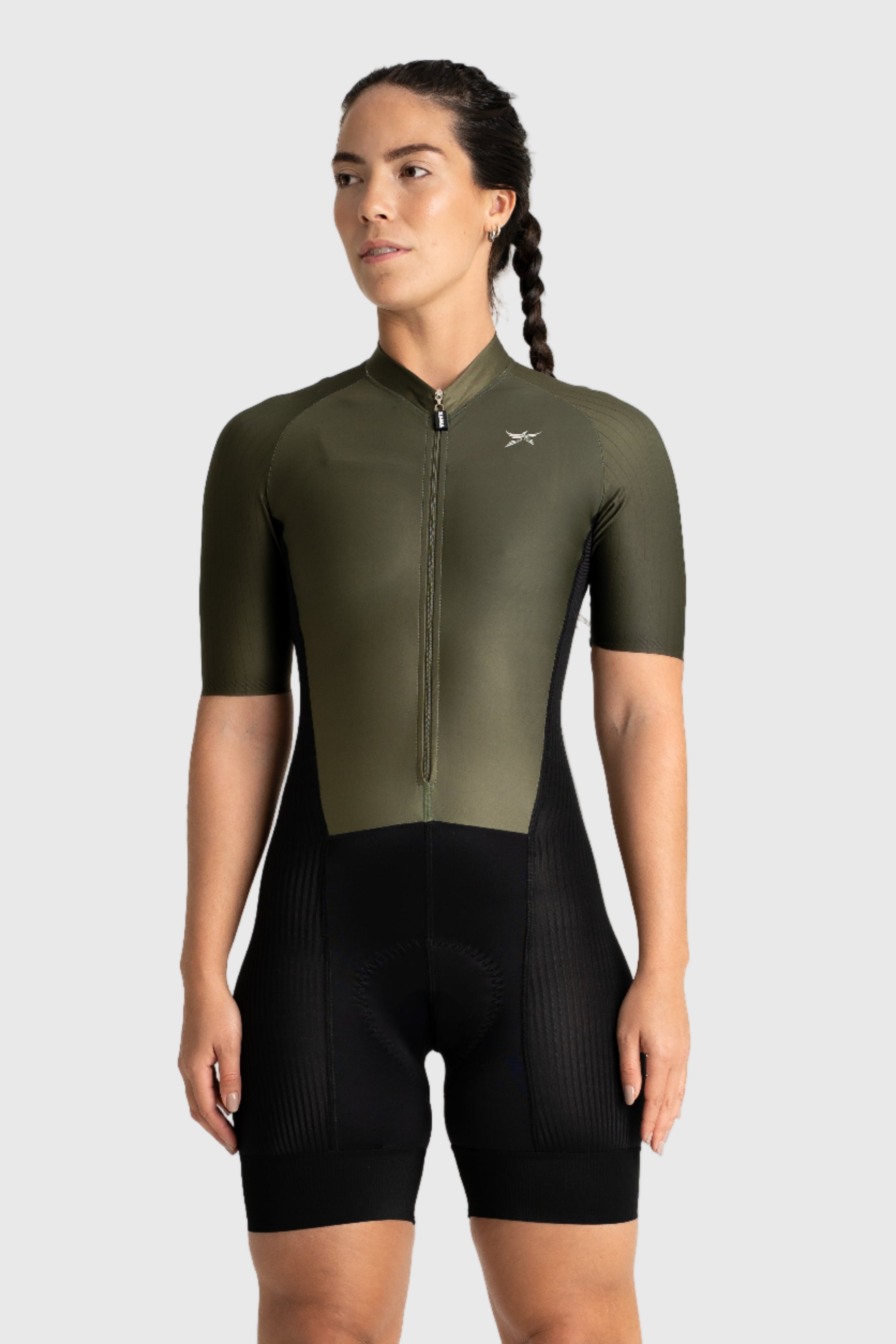 Person wearing an olive green cycling jersey and black shorts on a white background