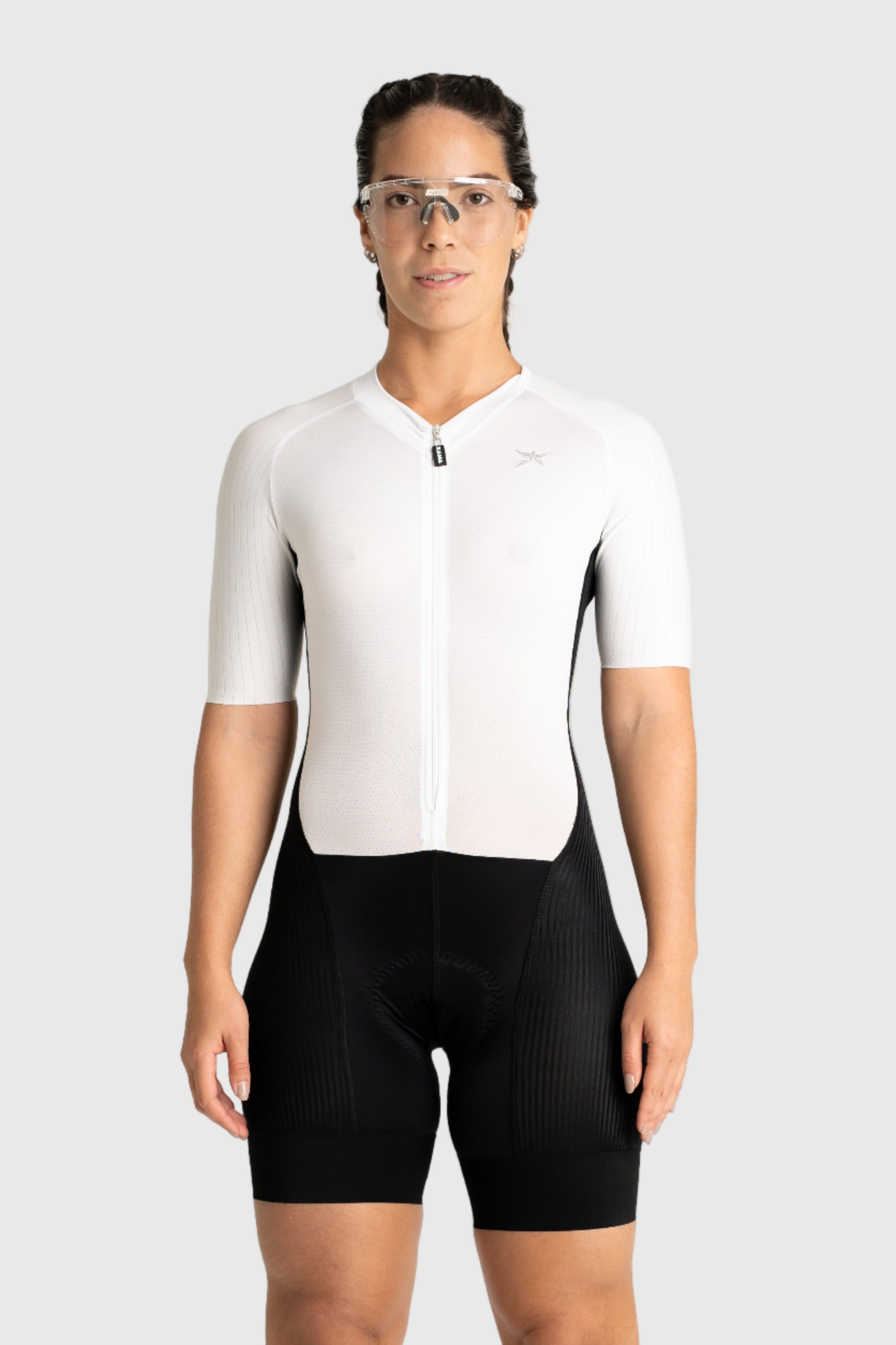 Person wearing a white cycling jersey and black shorts on a white background