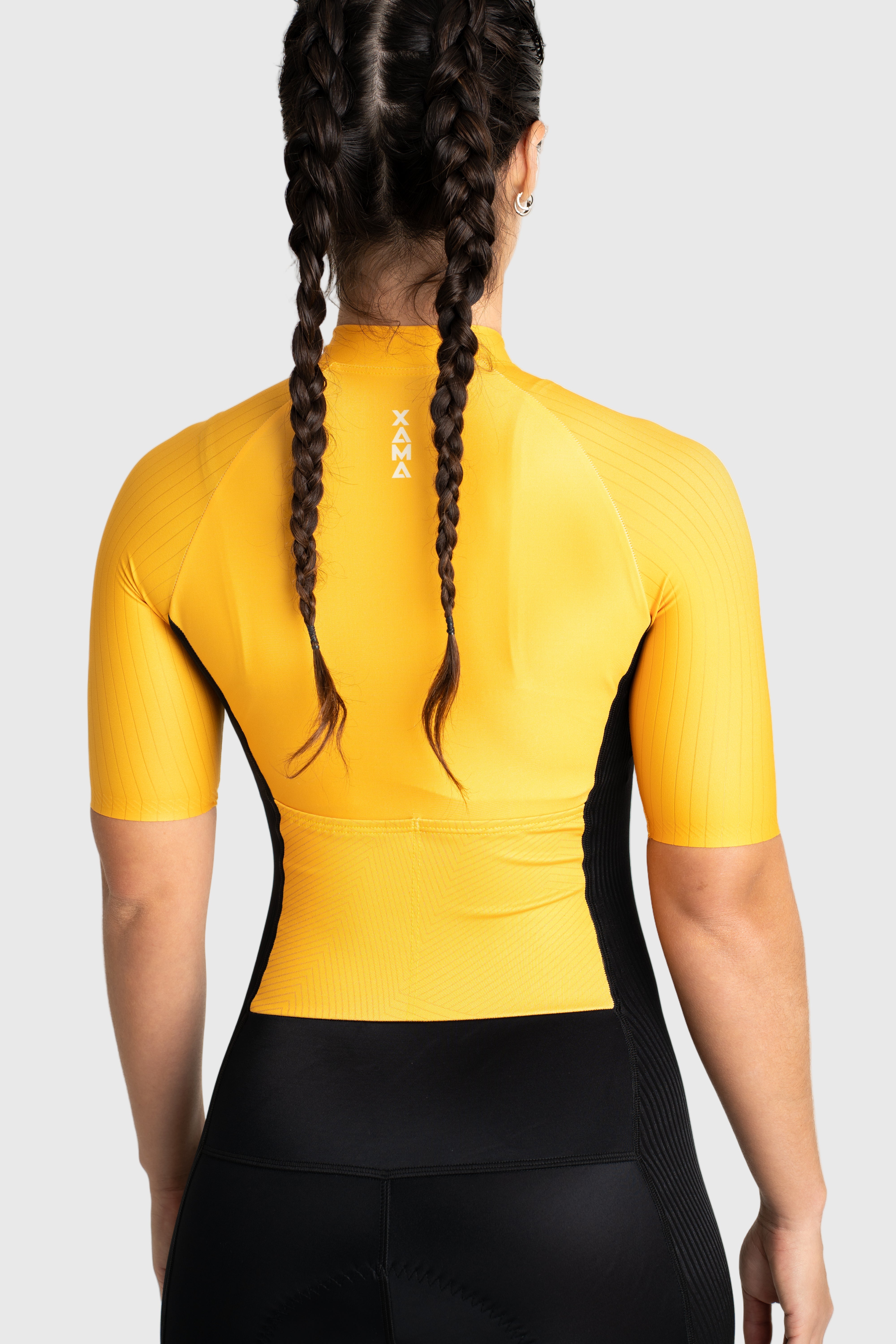 Person wearing a yellow cycling jersey with a visible brand logo on a white background