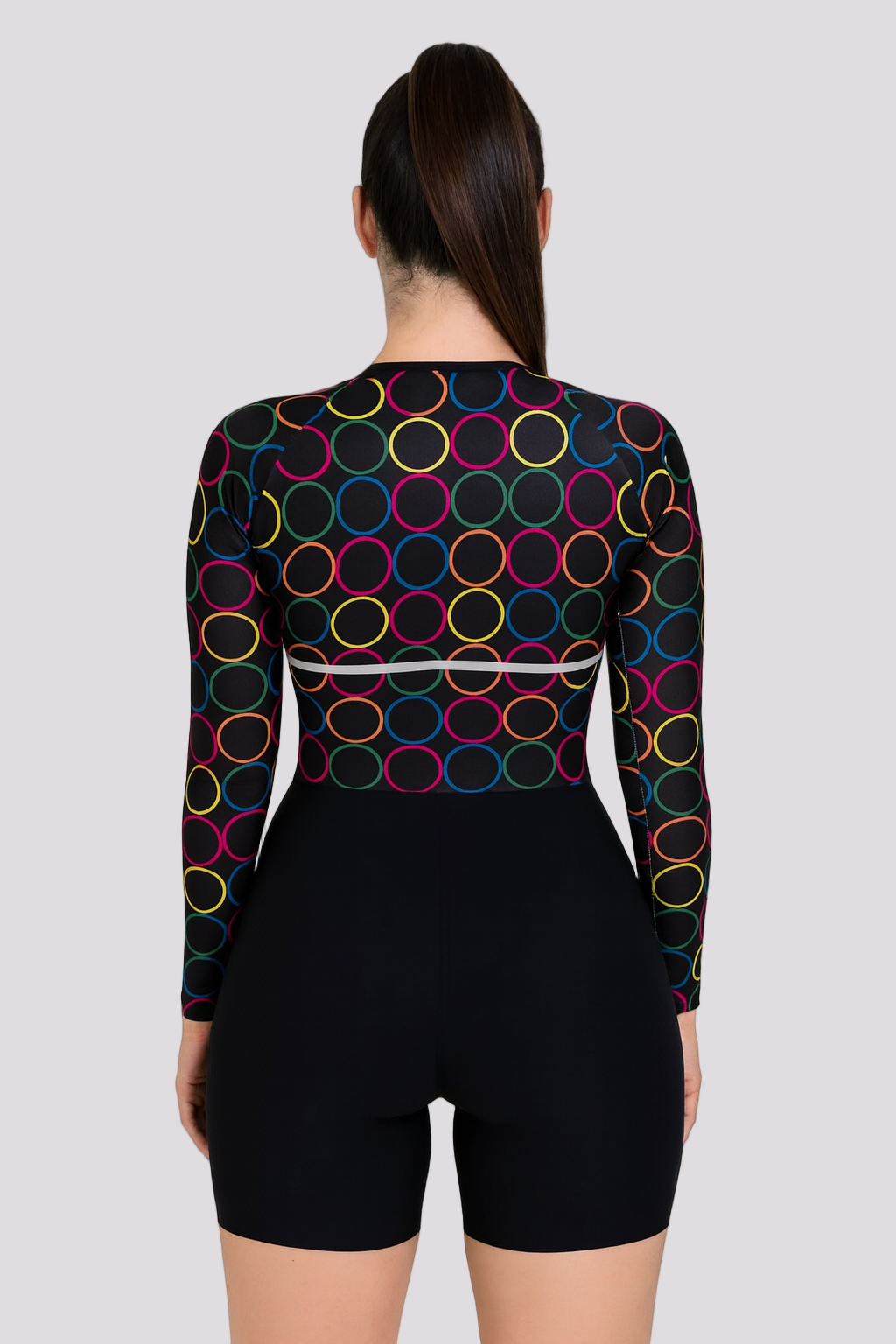 Person wearing a black bodysuit with colorful circle patterns on a white background