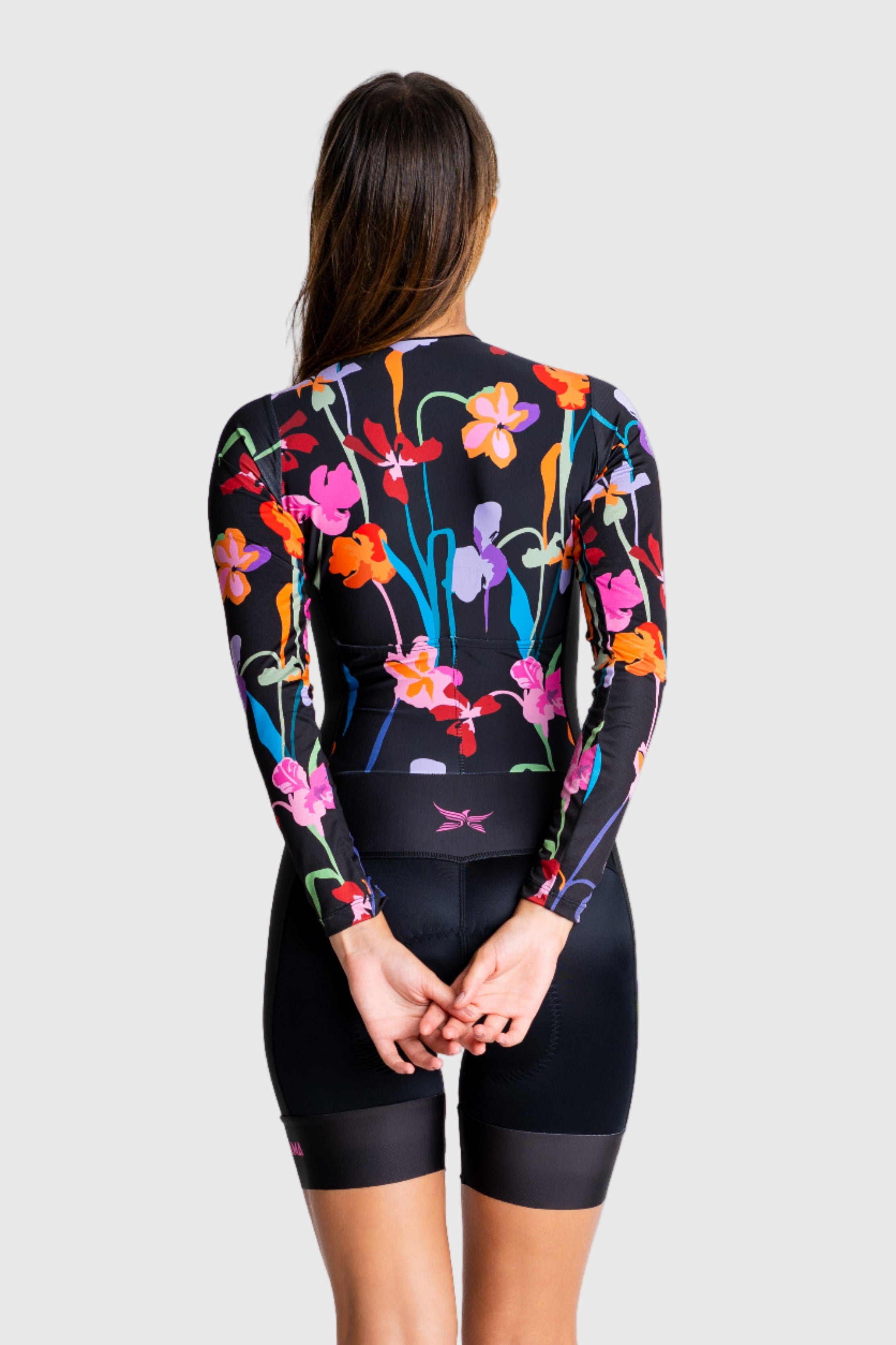 Person wearing a colorful floral cycling outfit on a white background