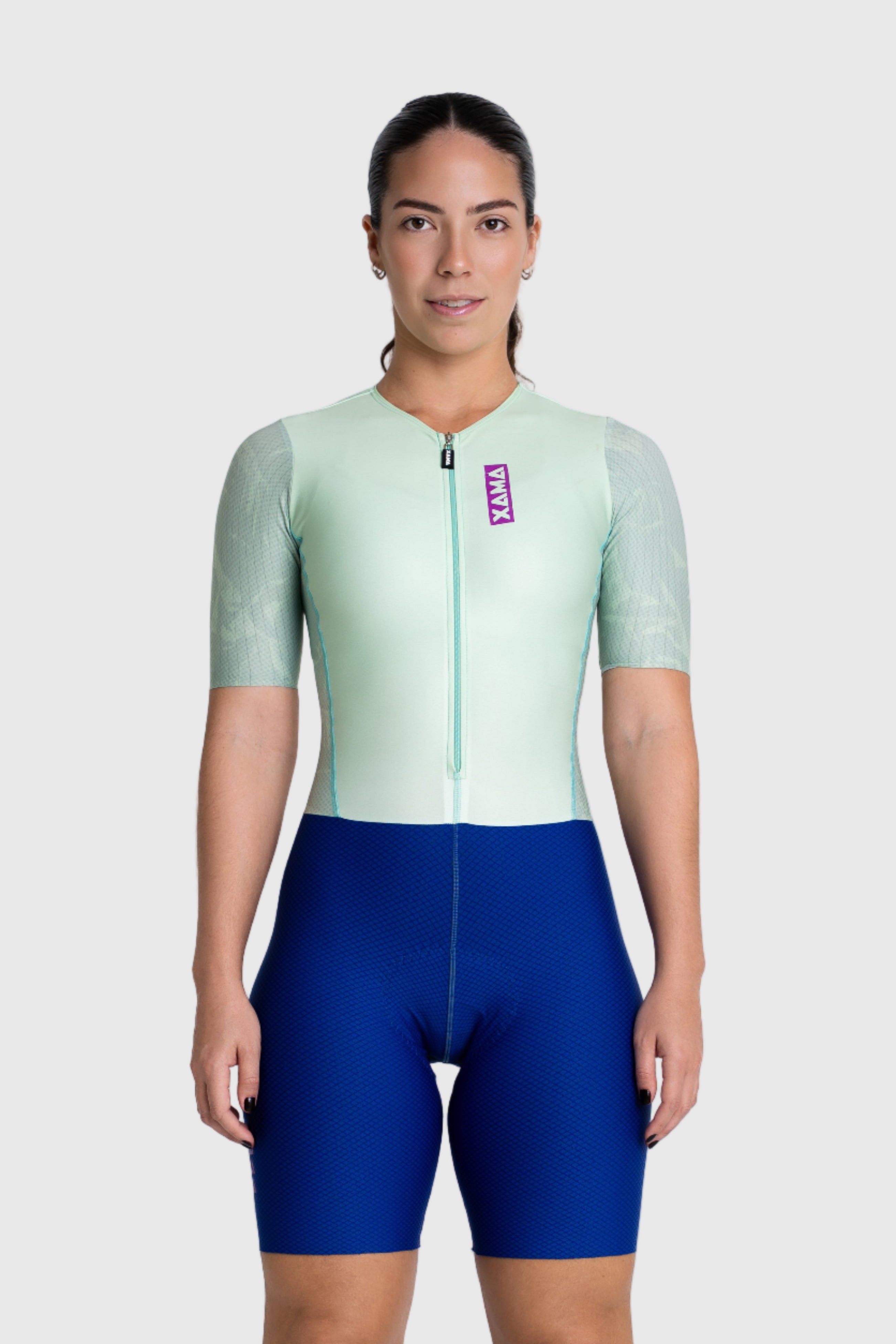 Person wearing a green and blue cycling outfit on a white background