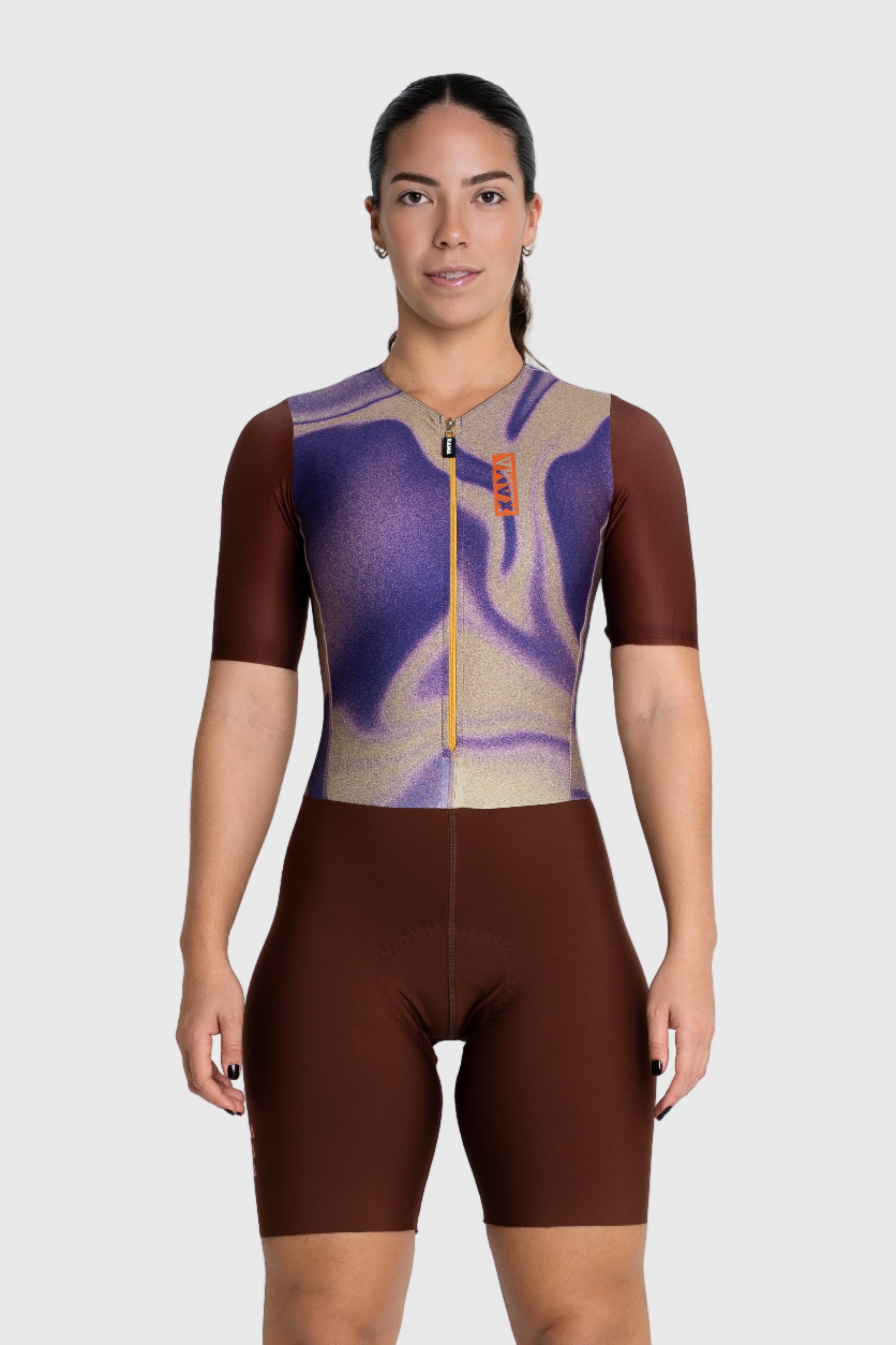 Person wearing a brown and purple cycling outfit on a white background