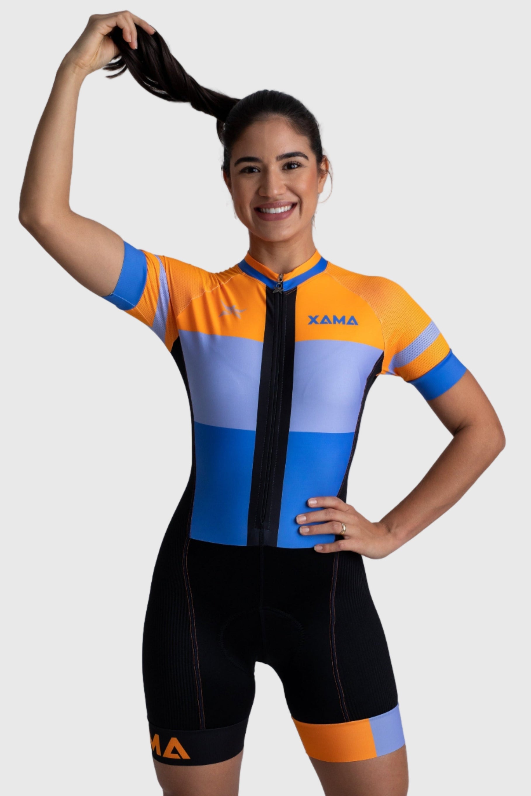 Woman wearing a colorful cycling suit with 'Xama' branding on a white background