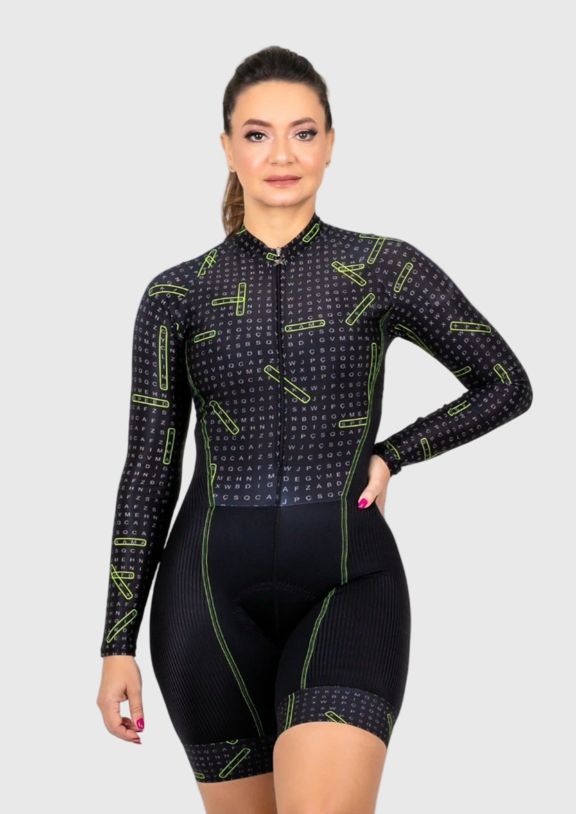 Woman wearing a black and green cycling suit on a white background