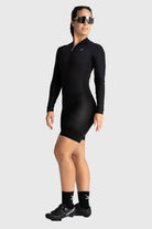 Person wearing a black long-sleeve athletic outfit on a white background