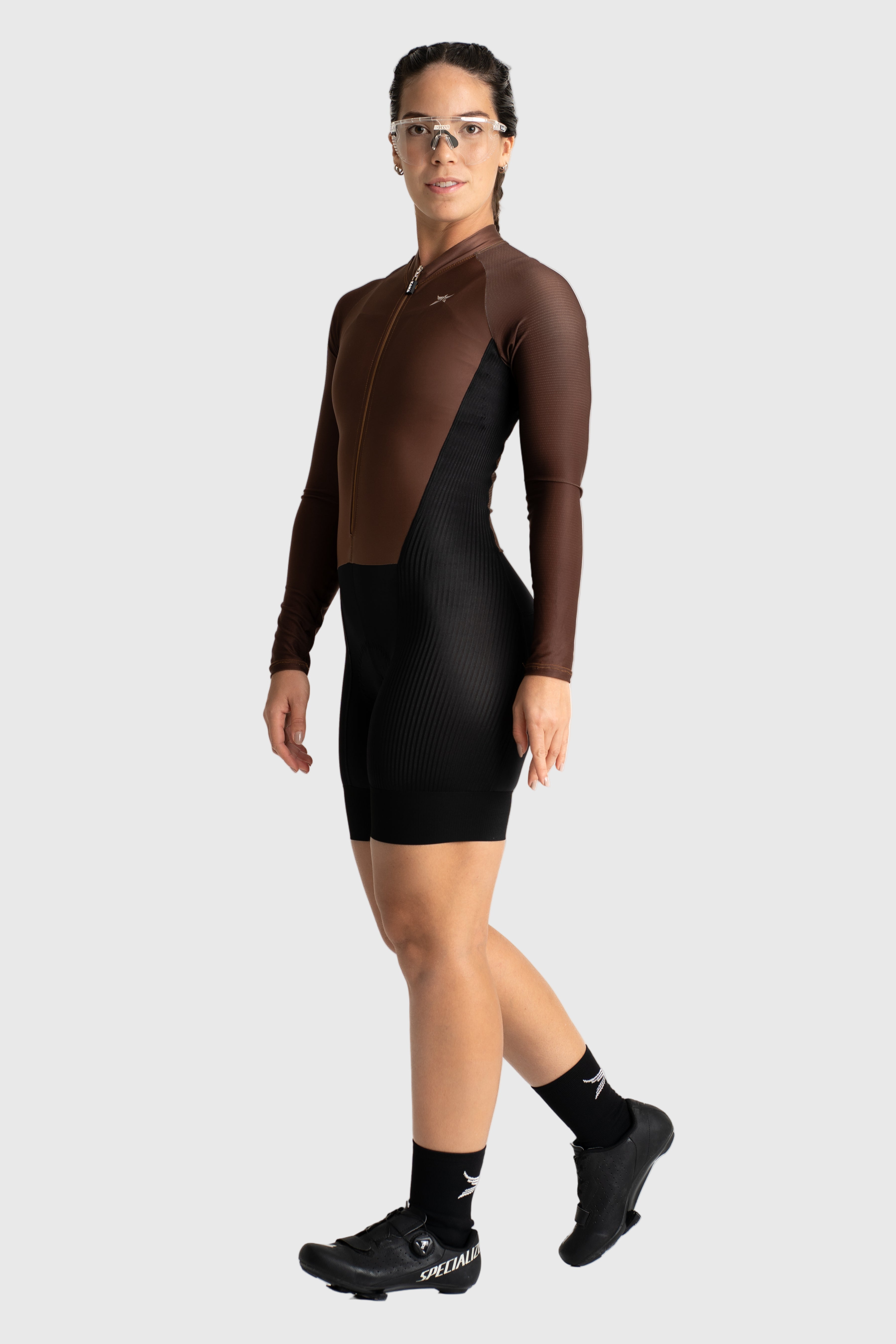 Person wearing a brown and black long-sleeve athletic outfit on a white background