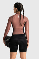 Person wearing a brown athletic top and black shorts on a white background