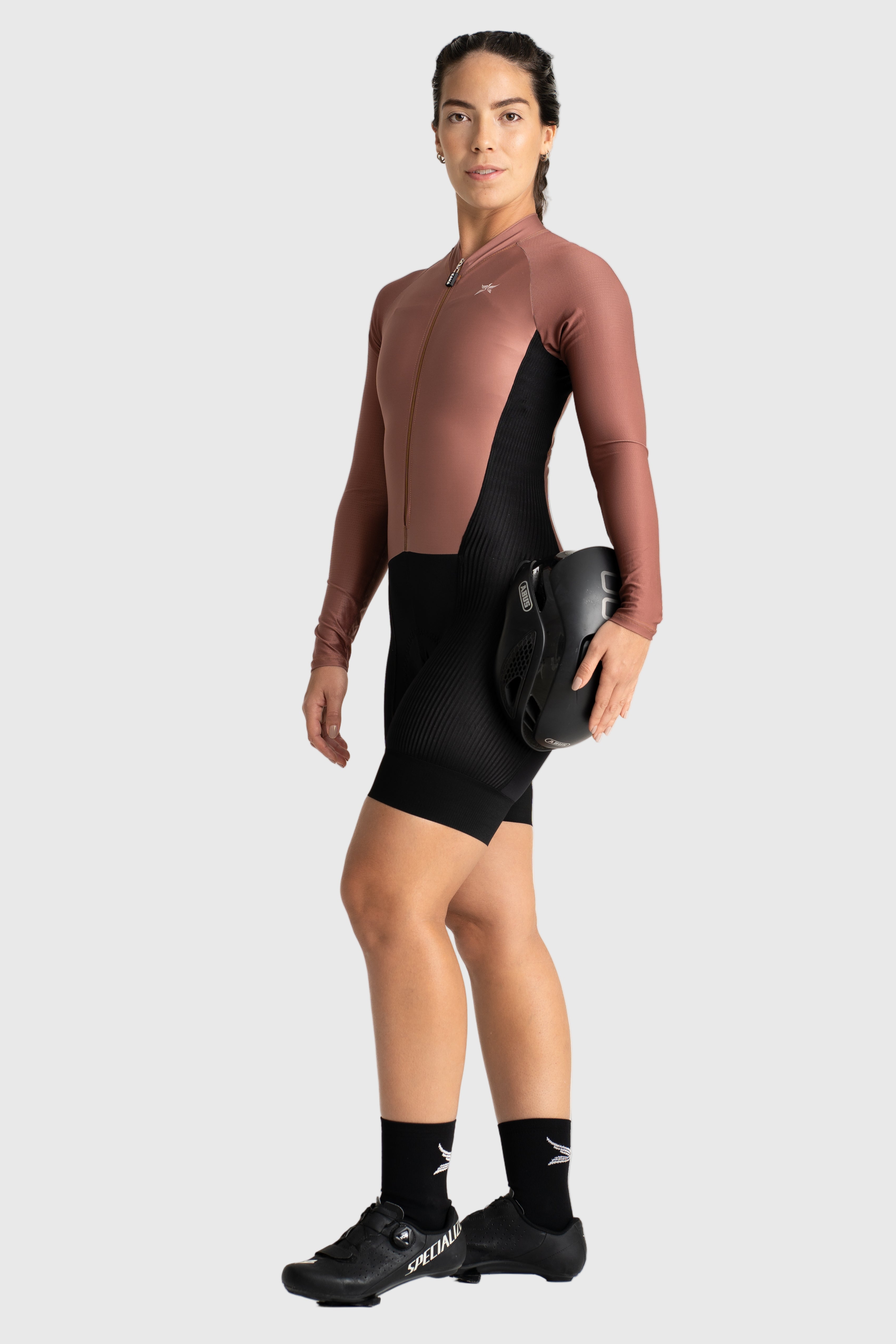 Person wearing a brown and black cycling outfit on a white background