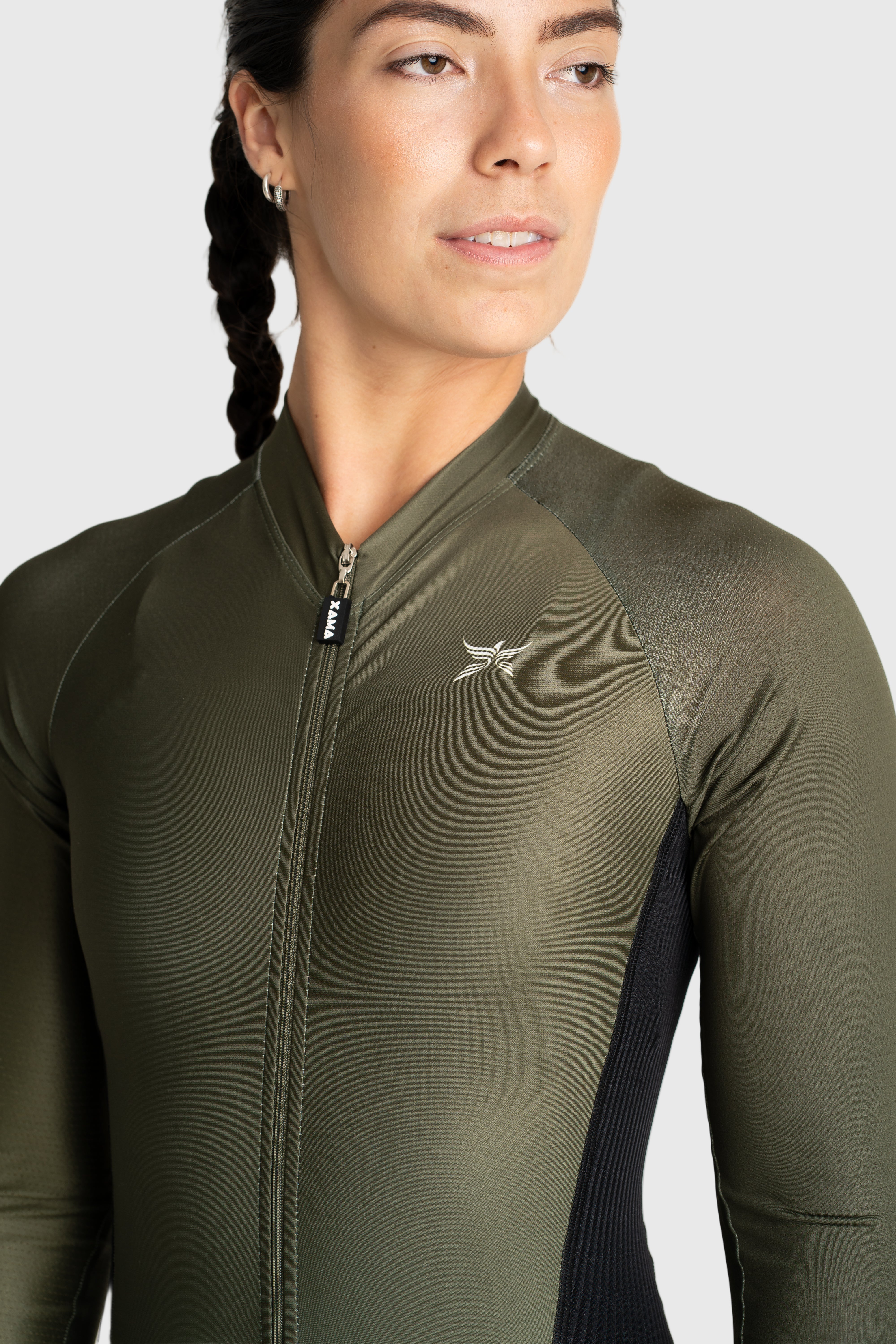 Person wearing a green athletic jacket with a logo on a white background