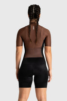 Person wearing a brown and black cycling outfit on a white background