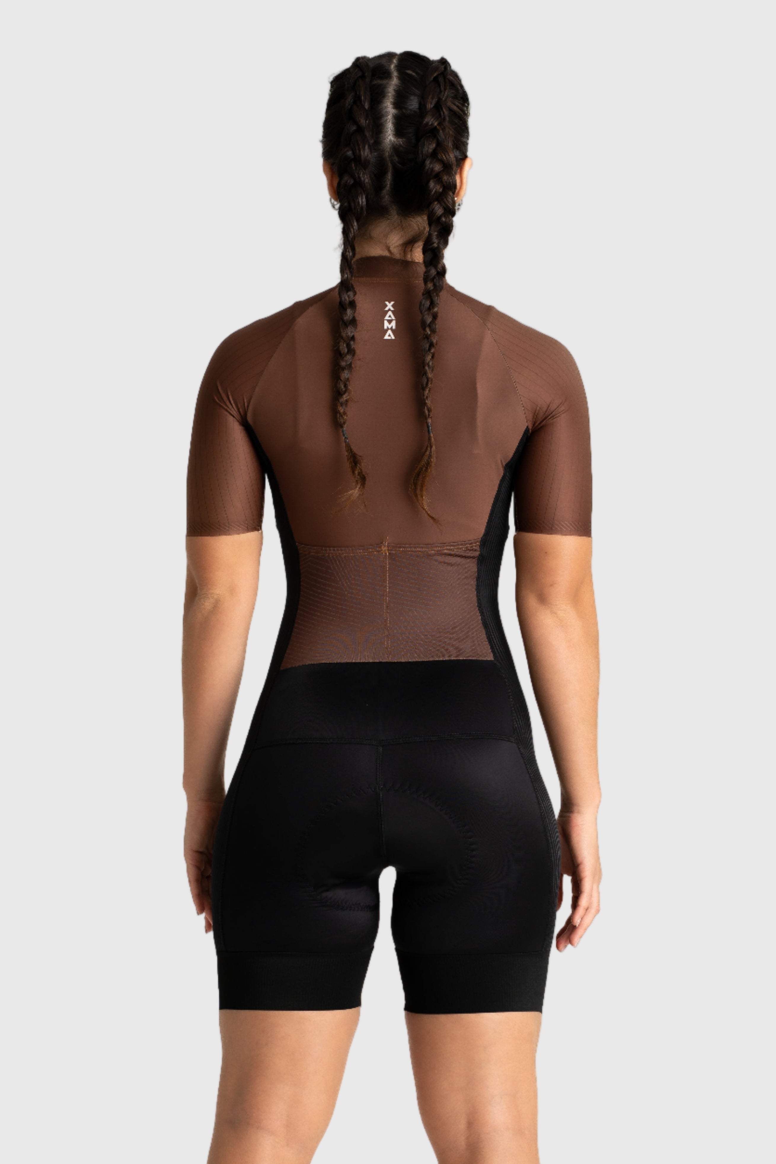 Person wearing a brown and black cycling outfit on a white background