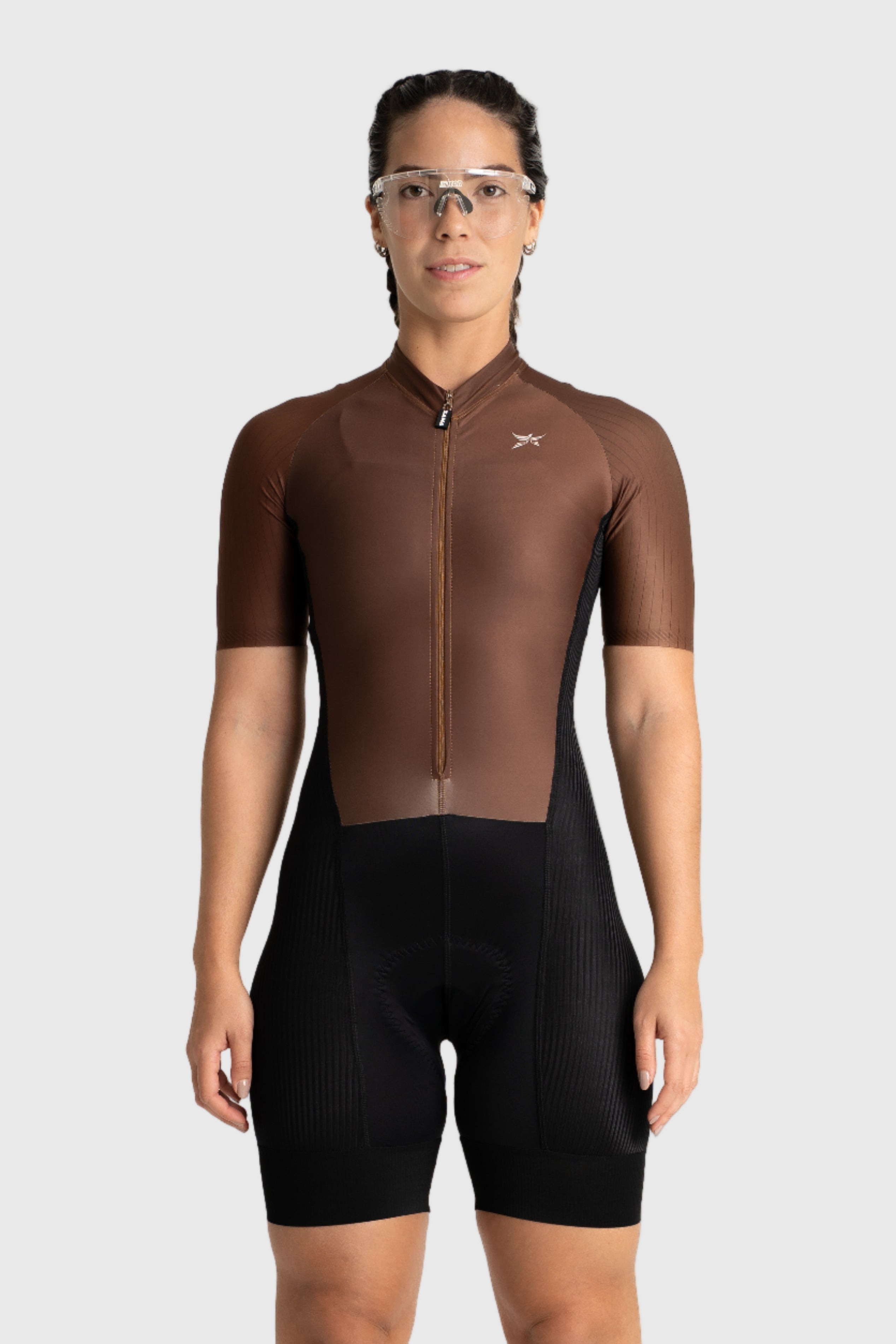 Person wearing a brown cycling jersey and black shorts on a white background