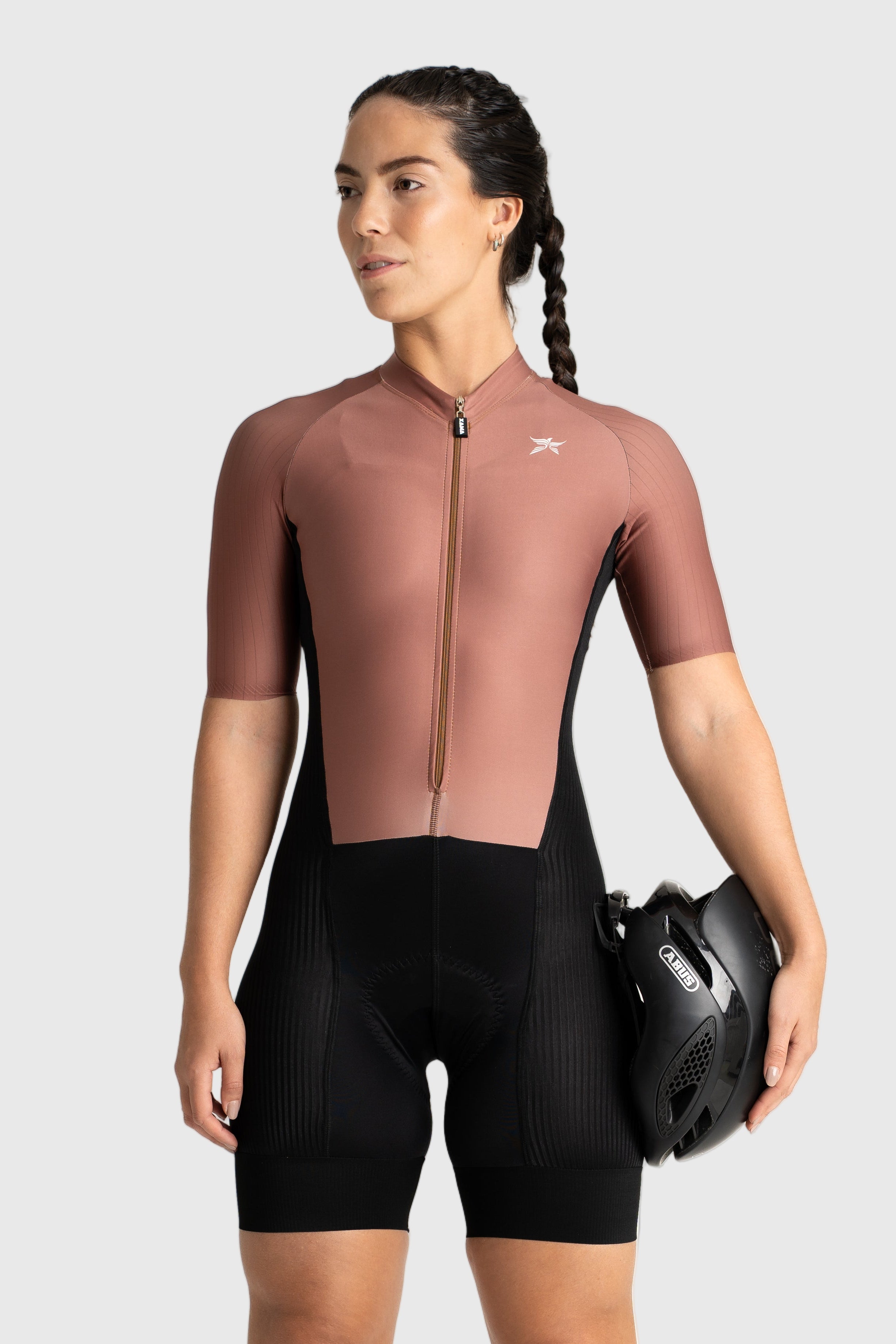 Person wearing a pink cycling jersey and black shorts with a helmet on a white background