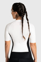 Person wearing a white cycling jersey with black shorts on a white background