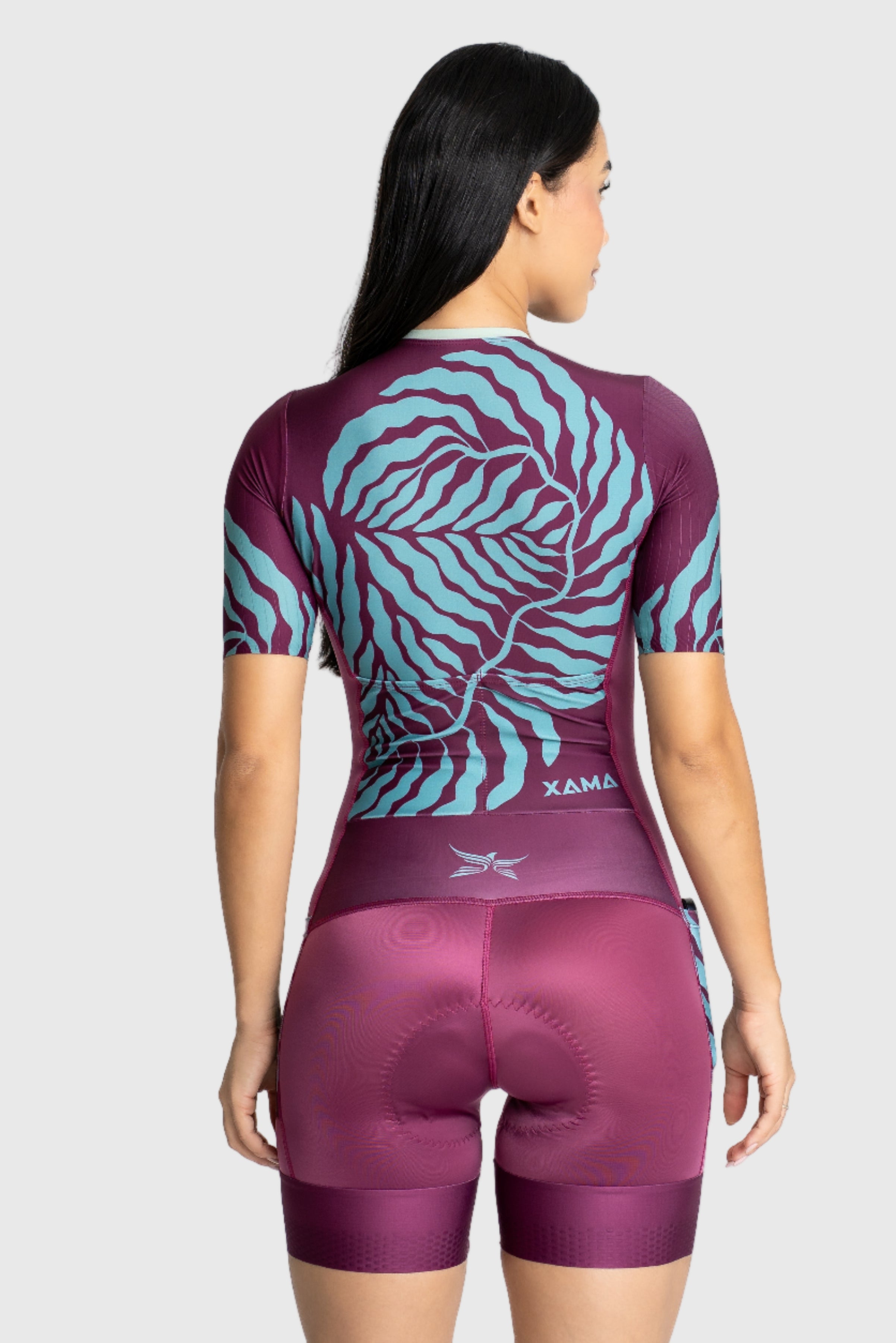 Person wearing a maroon and blue cycling outfit with a tiger design on the back, on a white background.