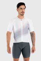 Man wearing a white cycling jersey and gray shorts on a white background