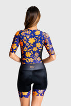 Woman wearing a colorful floral cycling outfit on a white background