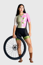 Woman wearing a colorful cycling outfit holding a bicycle wheel on a white background