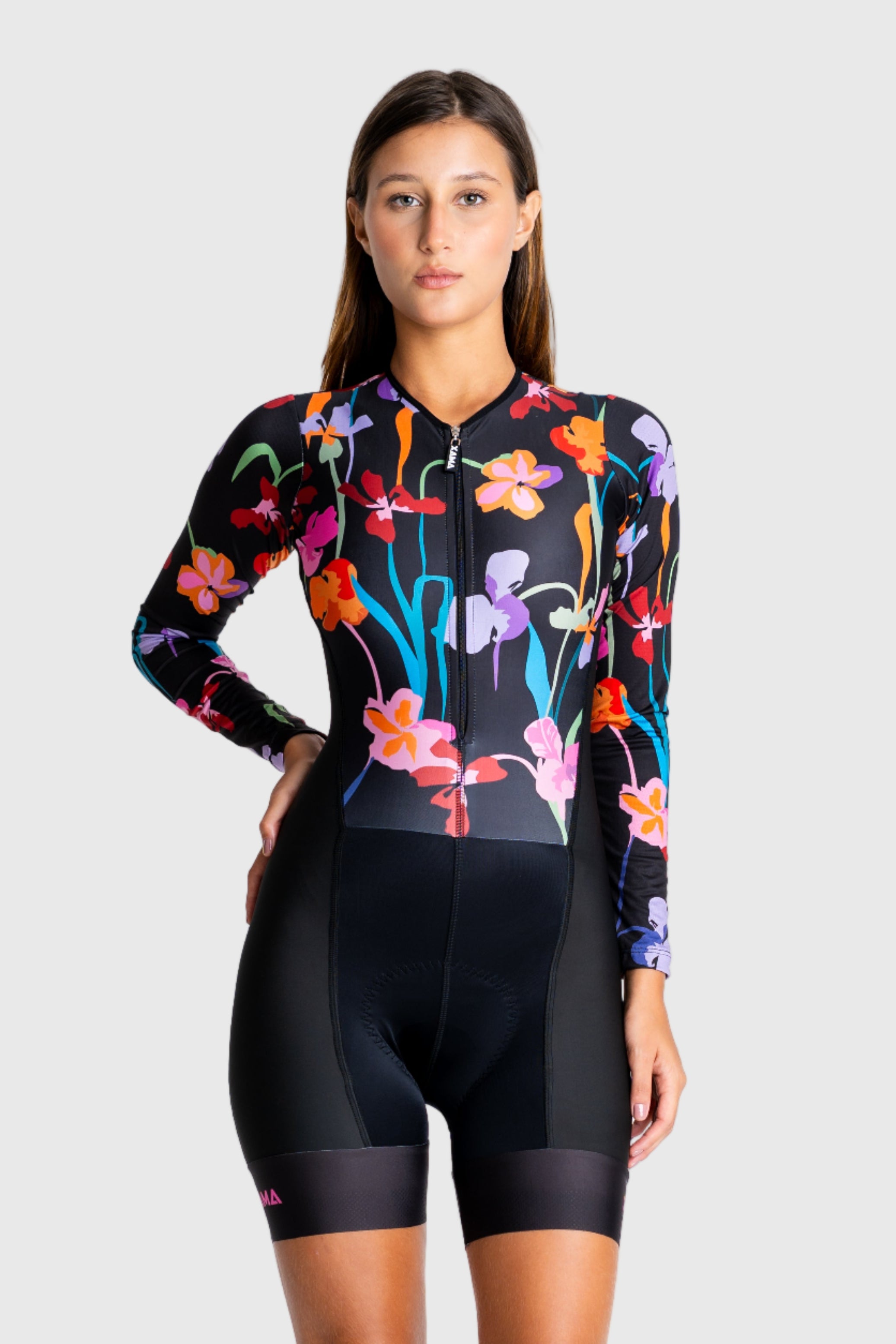 Woman wearing a colorful floral cycling outfit on a white background