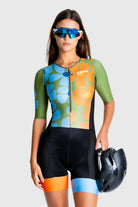 Person wearing a colorful cycling outfit with a helmet on a white background