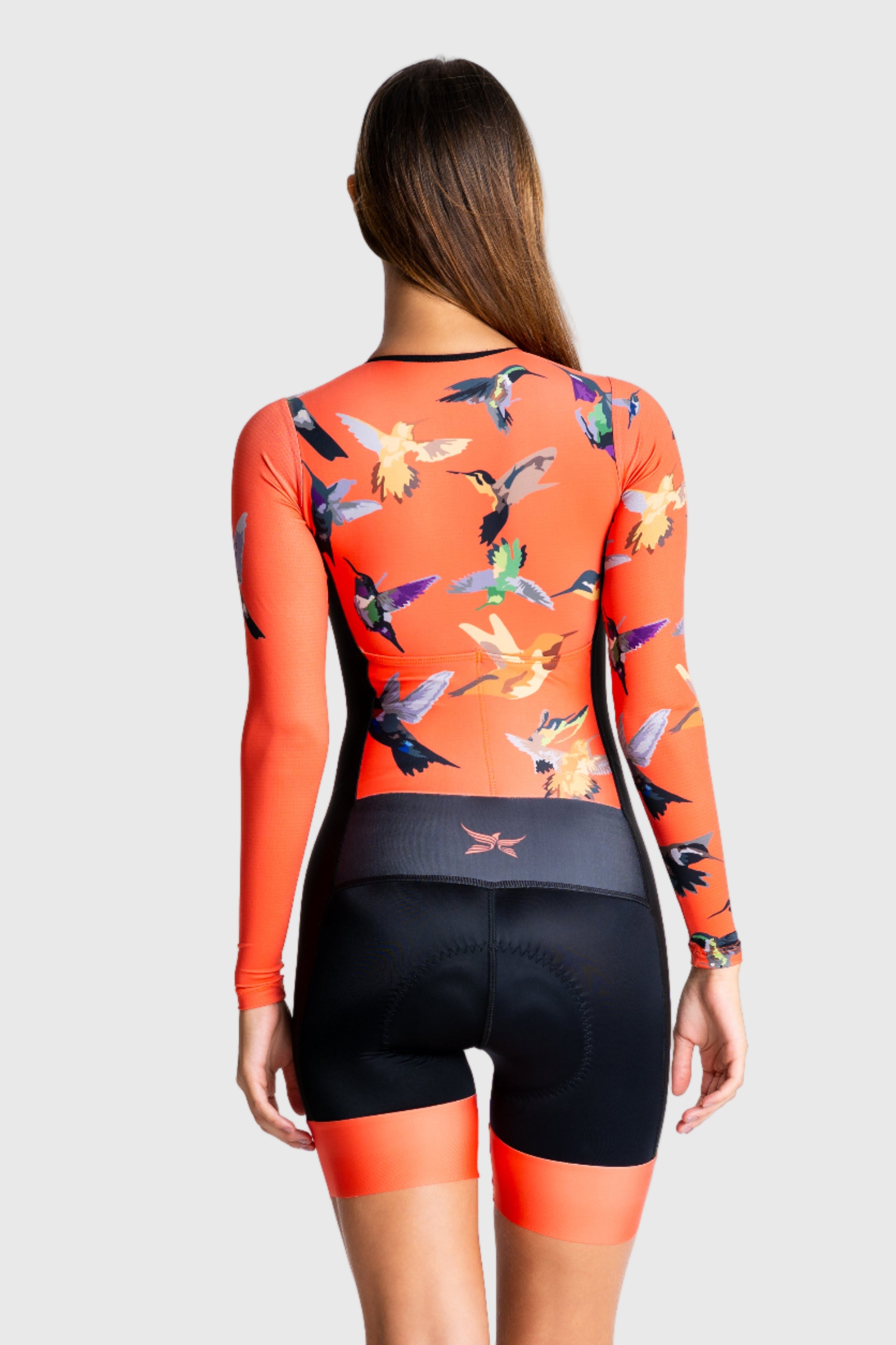 Person wearing a colorful long-sleeve top and black shorts on a white background