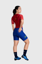 Person wearing a red and blue cycling outfit with visible branding on a white background