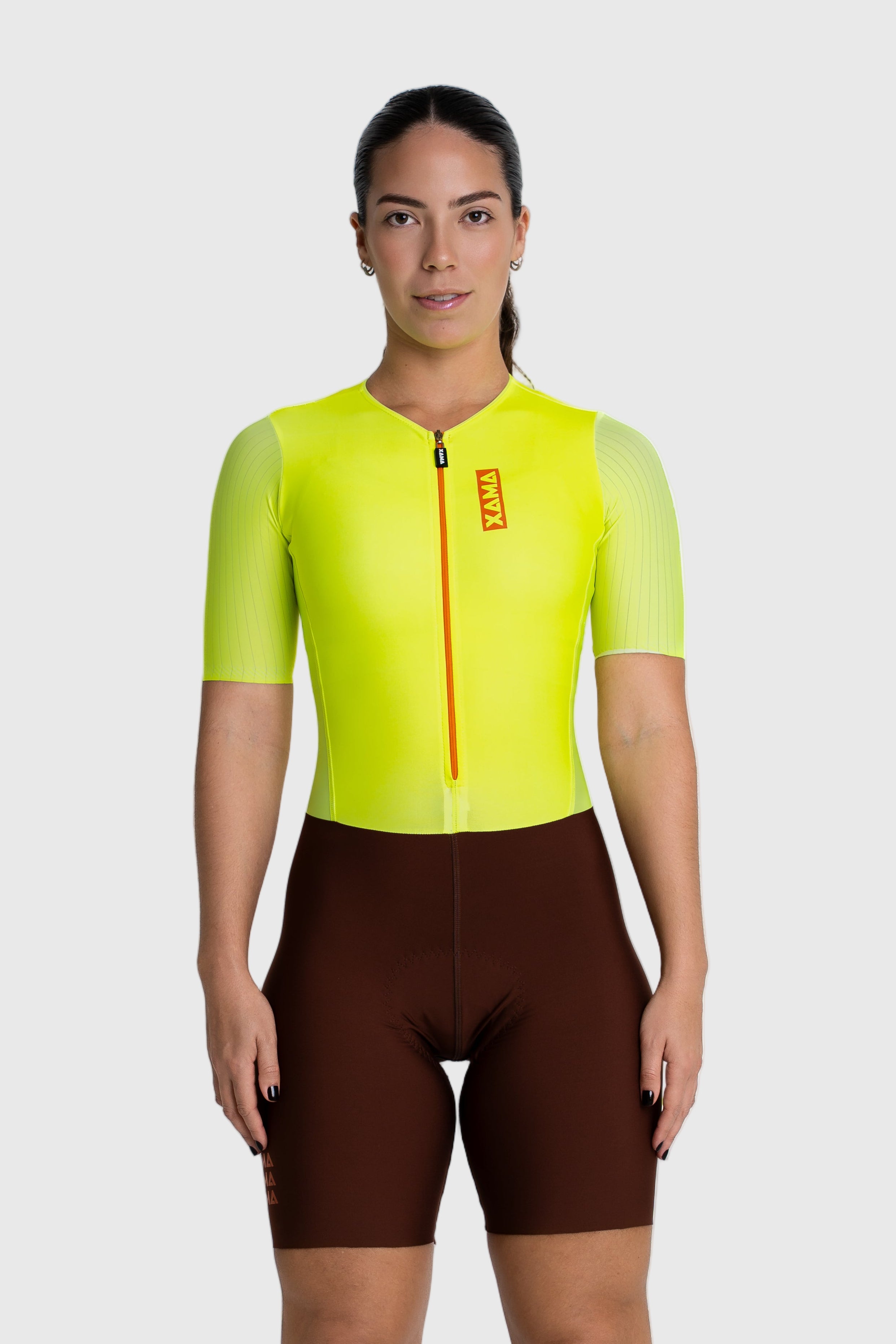 Person wearing a bright yellow cycling jersey and brown shorts on a white background