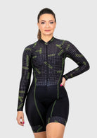 Woman wearing a black and green cycling suit on a white background